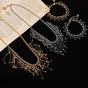 Detailed view of gold and silver lace tassel necklaces and bracelets set on a book