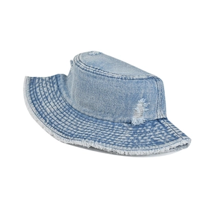 Detail of washed denim bucket hat with distressed edges and frayed brim texture