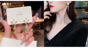Macro shot of 925 silver star tassel earrings with white enamel and sparkling rhinestones