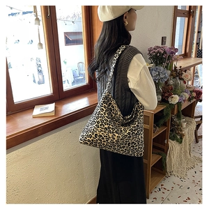 Fashionable large capacity leopard print tote bag shown on a model's shoulder indoors
