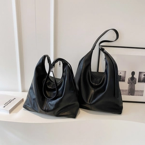 Macro shot showing small and large black leather hobo tote bags with premium texture