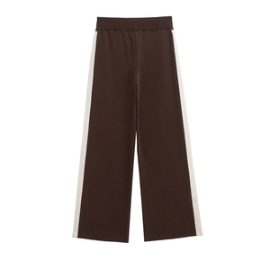 Detail view of dark brown wide-leg trousers with stylish cream side stripe accents