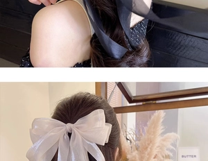 Detail of oversized bow hair clip in black and cream voile on natural hair