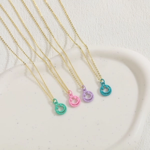 Minimalist gold necklaces with colorful smiley face pendants in green, pink, and blue