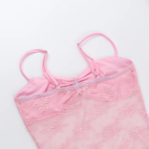 Close-up of pink lace camisole with adjustable thin straps and intricate floral textures