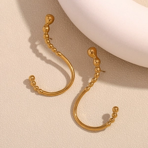 Detailed macro view of 18K gold-plated stainless steel earrings with unique curved bead texture