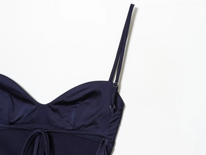 Detail of adjustable straps and satin texture on a navy blue lace slip dress