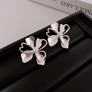 Close-up of silver flower earrings with diamond centers in a black jewelry box