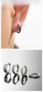 Close-up of retro silver twist and heart earrings with vintage engraved patterns