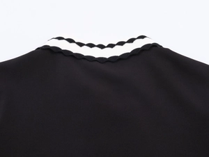 Detail of contrast wavy knit polo collar with black and white scallop edge stitching
