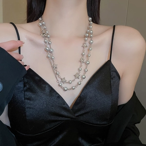Close-up of double-layer silver beaded necklace featuring a star pendant on model