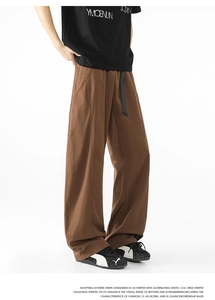 Detalle de pantalones marrones de pierna ancha con cintura elástica y cordón negro