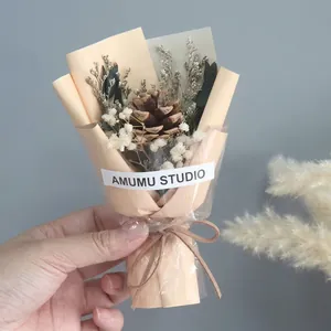 Detailed view of mini dried flower bouquet with pine cones and baby's breath wrapping