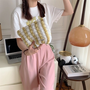 Close-up of yellow and white striped bubble canvas cosmetic bag held in hand