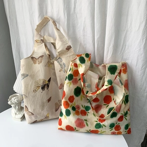 Detail view of canvas shopping bags with butterfly print and red-green floral patterns