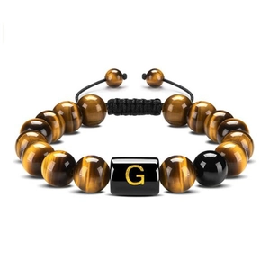 Detailed shot of 10mm tiger eye stone beads and black letter G charm on woven bracelet