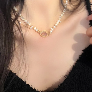 Detail of double-layer necklace with faux pearls and pink crystal pendant on model