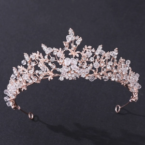 Elegant rose gold bridal crown with crystals and leaf motifs on a dark background