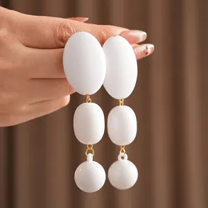 Vintage geometric triple-tier white drop earrings with gold-plated metal accents