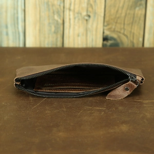 Detailed view of the brown leather wallet interior showing compartments and zipper