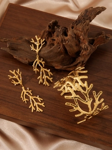 Détail d'une parure en forme de branche plaquée or 18k avec perles sur bois vintage