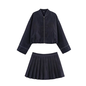 Flat lay of a navy denim two-piece set with white contrast stitching and pleated skirt