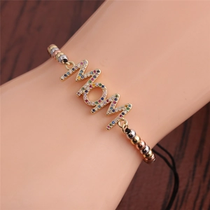 Close-up of gold MOM bracelet with colorful zircon stones worn on the wrist
