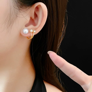 Vue détaillée de boucles d'oreilles dorées à double couche avec perles et strass brillants