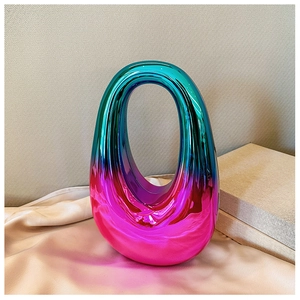 Detail view of the gradient iridescent finish and oval cutout handle on the acrylic clutch bag