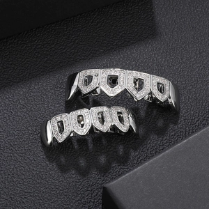 Silver hip hop grillz set with cubic zirconia stones on black leather background