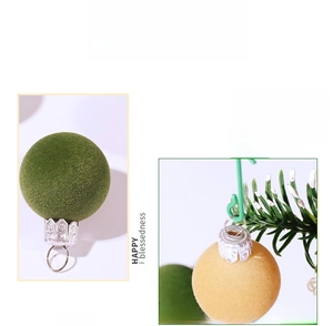 Detailed view of moss green and mustard yellow velvet Christmas ball ornaments with silver caps
