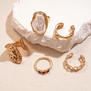 Detailed view of 5-piece gold geometric ring set with crystals and faux pearl