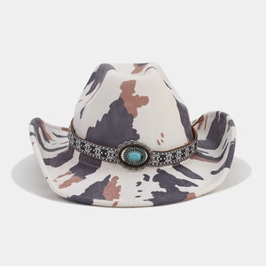 Detailed view of western cow print hat with ethnic embroidery and turquoise buckle ornament