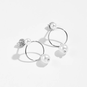 Macro shot of S925 sterling silver frame and white pearls on minimalist earrings