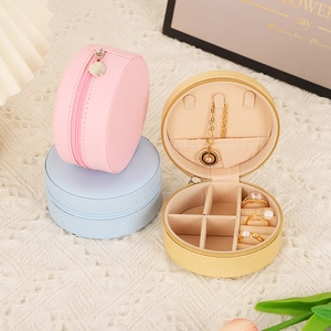 Portable round PU leather jewelry organizer in pink, blue, and yellow with ring slots