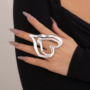 Exaggerated silver double heart ring with a stylish polished metal finish on hand