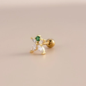 Close-up of golden flower stud earring with green zircon and ball screw back closure