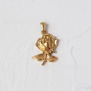 Macro detail of 18K gold-plated titanium steel rose pendant with 3D embossed texture