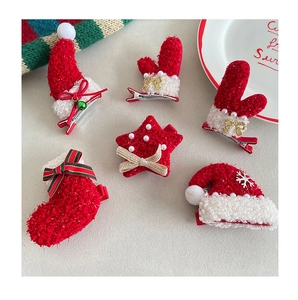 Detail of red and white plush Christmas hair clips featuring socks, stars and hat shapes
