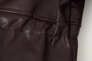Detailed close-up showing double stitching and leather texture on a PU jacket