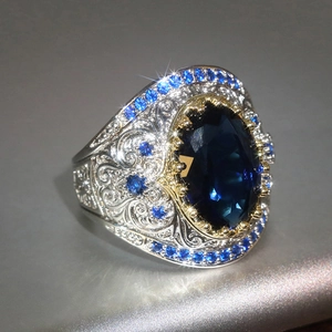 Dettaglio macro di un anello vintage con gemma blu e incisioni molto elaborate