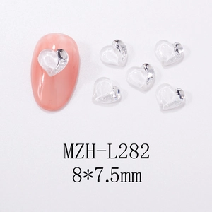 Detail view of 3D transparent heart resin nail charms on pink manicure tips, 8x7.5mm size
