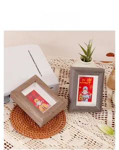 Miniature wooden frame with inspirational cards on a natural woven mat and white fabric