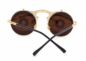 Macro detail of steampunk flip-up sunglasses with gold metal frame and eye-patterned lenses