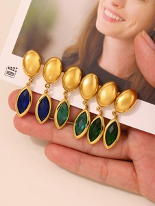 Détail de boucles d'oreilles pendantes en verre marquise bleu et vert avec fini doré