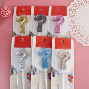 Showcase of metallic question mark birthday candles in six assorted colors on pink base