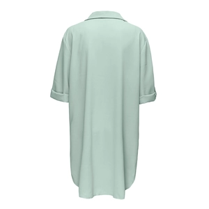 Detalle del dobladillo curvo y la tela verde claro de este vestido camisero oversize