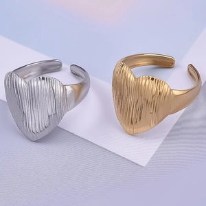 Détail de bagues cœur en or 18 carats et argent avec texture en métal brossé vertical