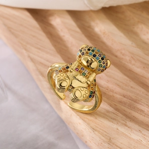 Close-up of 18K gold plated bear ring with colorful zircons on a wooden tray