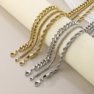 Detail of gold and silver cuban and twist necklaces on a neutral jewelry display